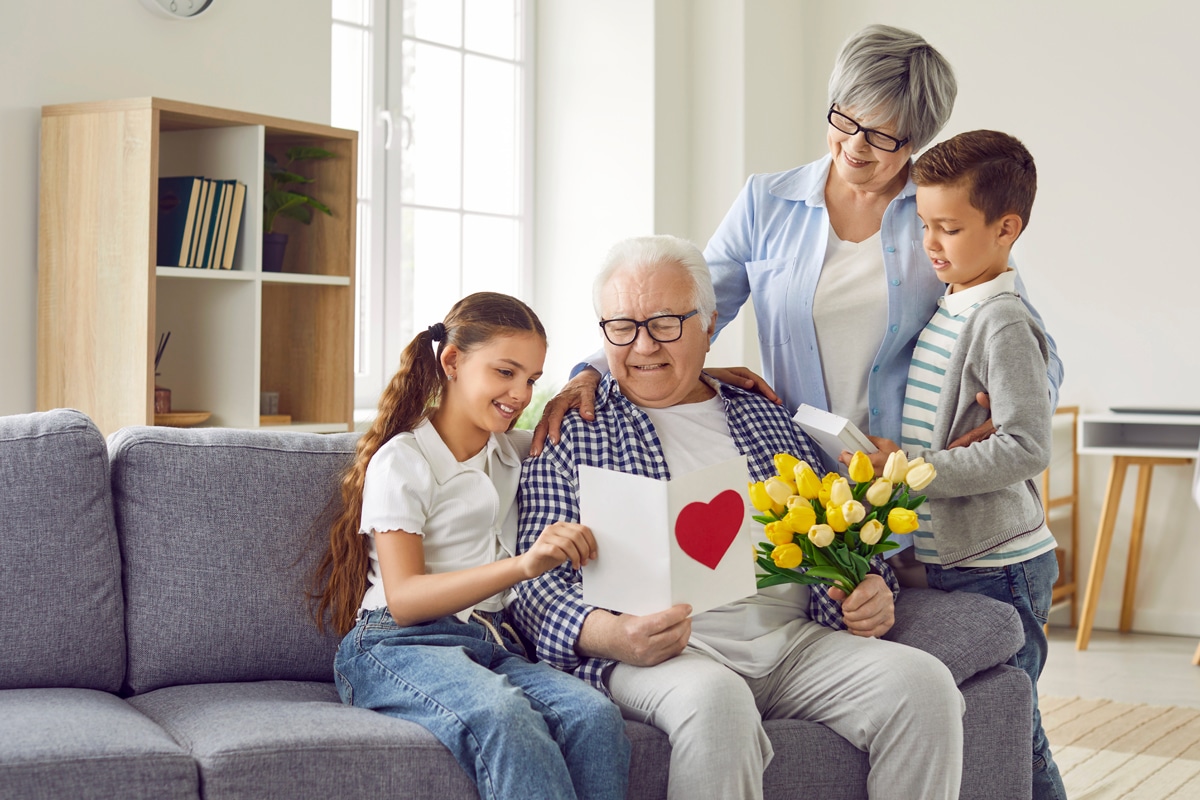 Grandparents looking at card with their grandkids