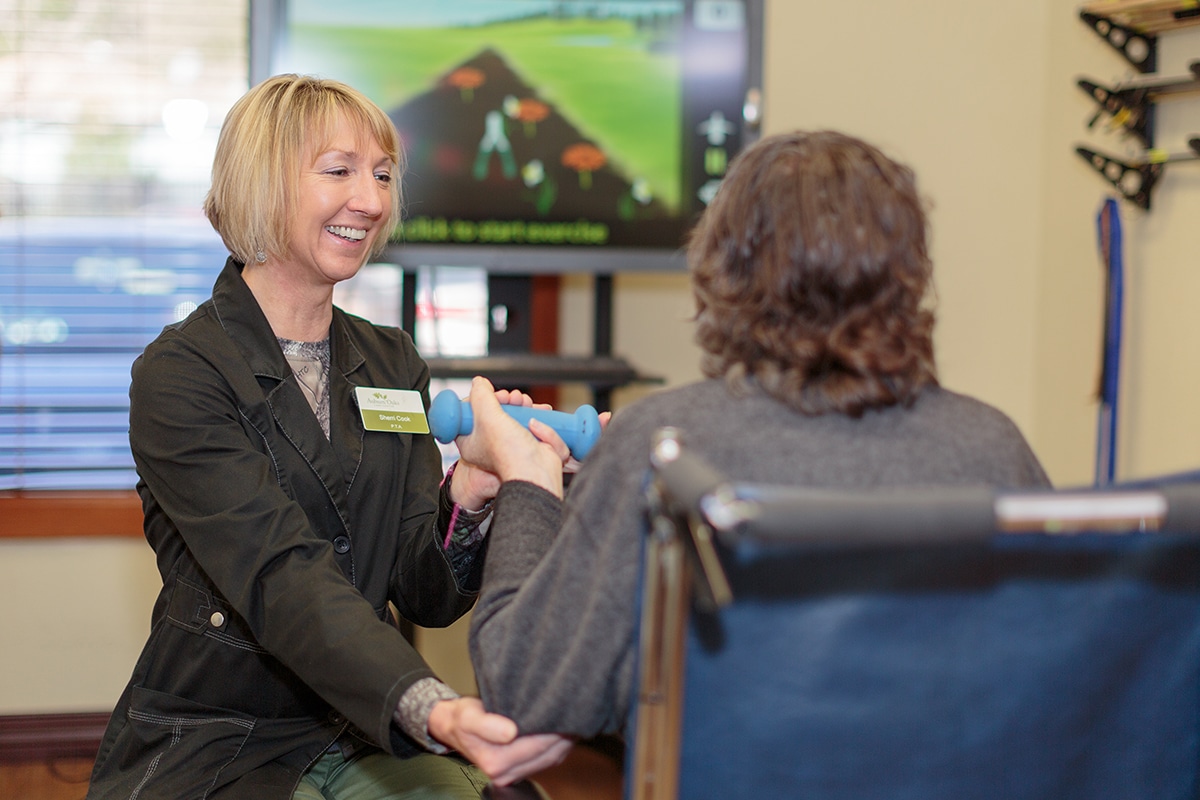 PACS-300x200-computer1 auburn oaks female staff member helping woman lift a weight by supporting her elbow