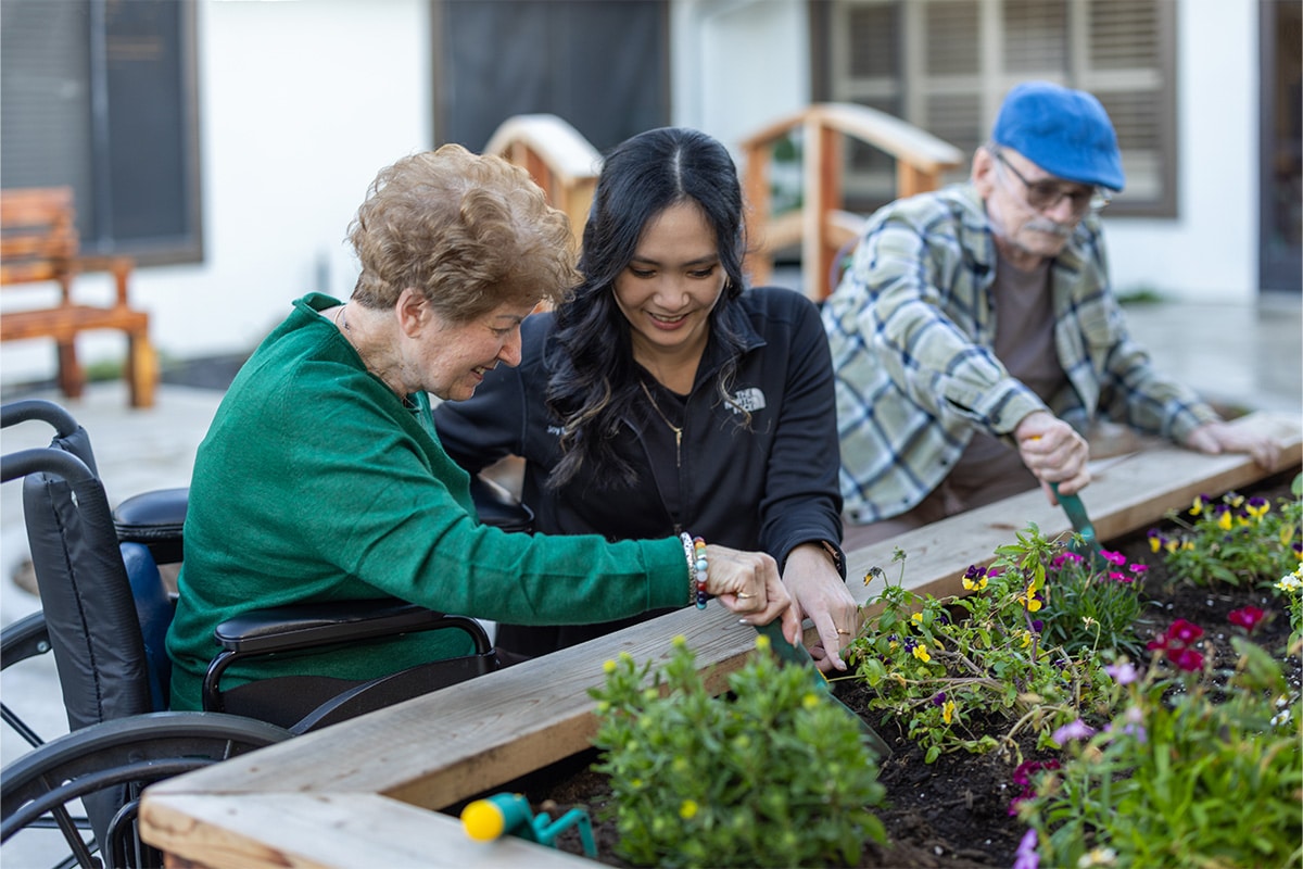 PACS-300x200-caregiver3 auburn oaks nurse helping elderly woman in a wheel chair plant flowers