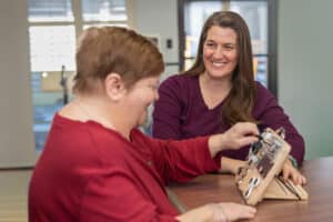 nurse assisting auburn oaks resident with occupational therapy